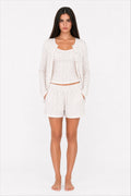 Woman wearing a white pajama set on a white background