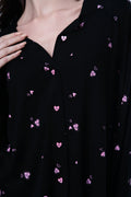 Black shirt with pink heart patterns worn by a person