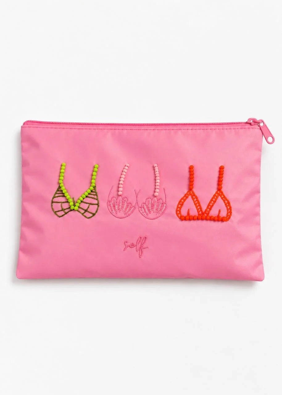 Pink pouch with embroidered designs on a textured surface