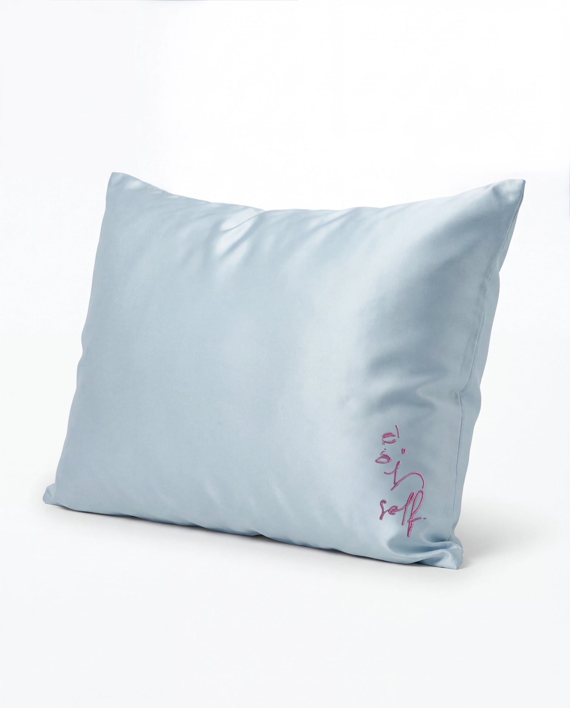 Light blue pillow with 'self' embroidery on a white background