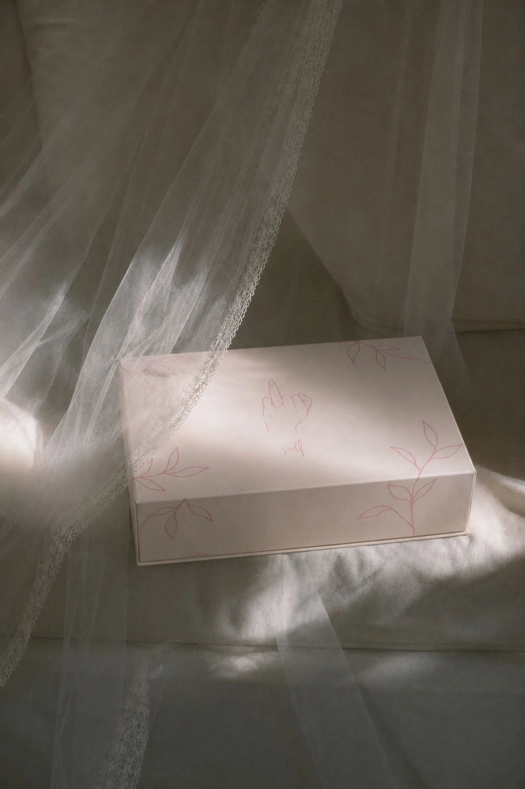 White box with floral patterns on a white fabric background