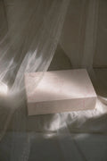 White box with floral patterns on a white fabric background