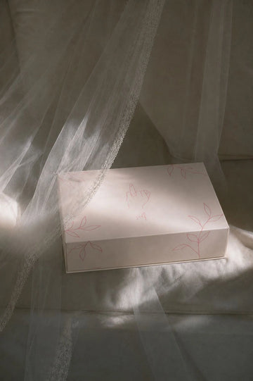 White box with floral patterns on a white fabric background