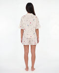 Woman wearing a floral pajama set on a white background