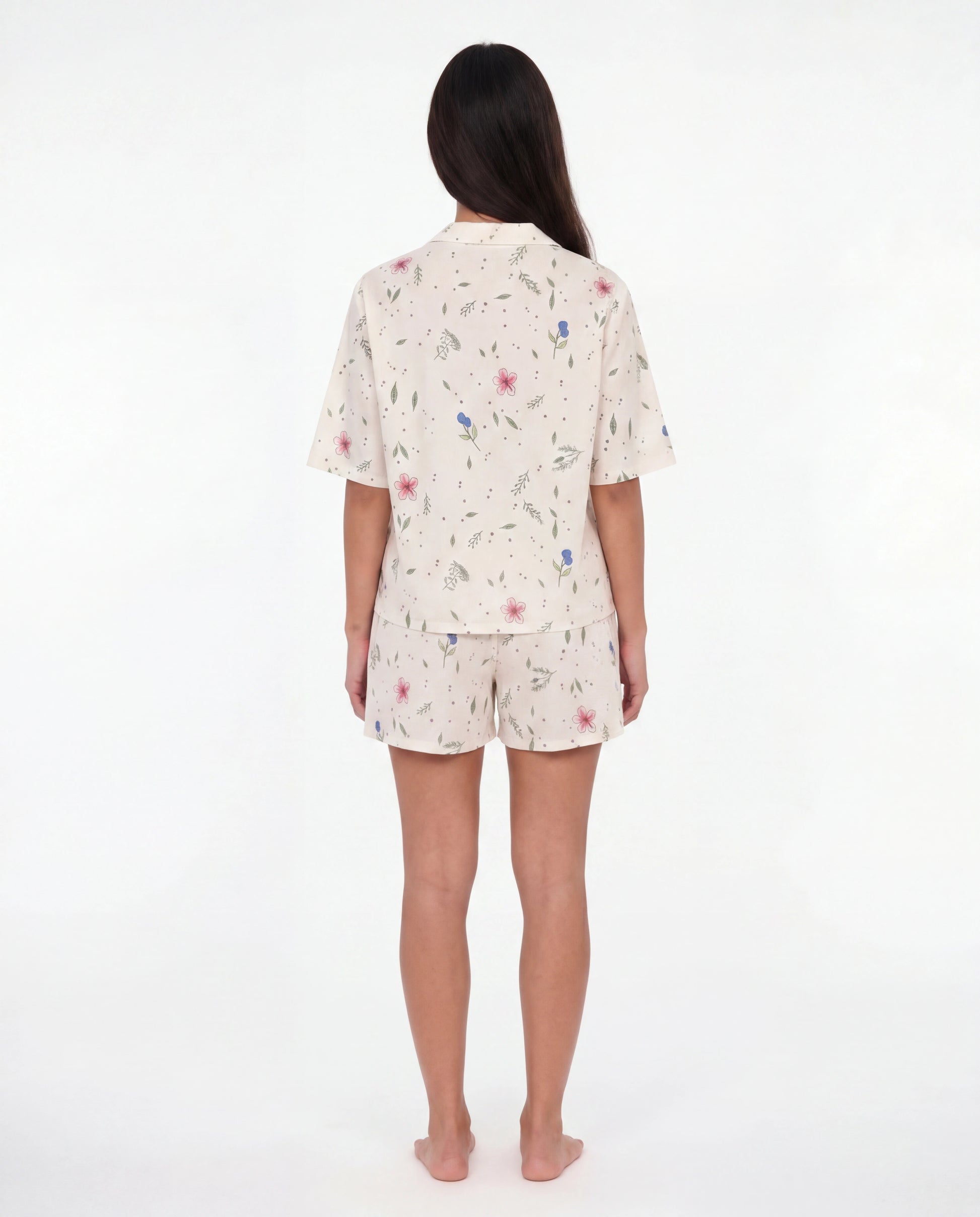 Woman wearing a floral pajama set on a white background