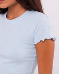 Light blue t-shirt with scalloped sleeves worn by a person on a white background