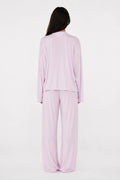 Person wearing a lilac pajama set on a white background