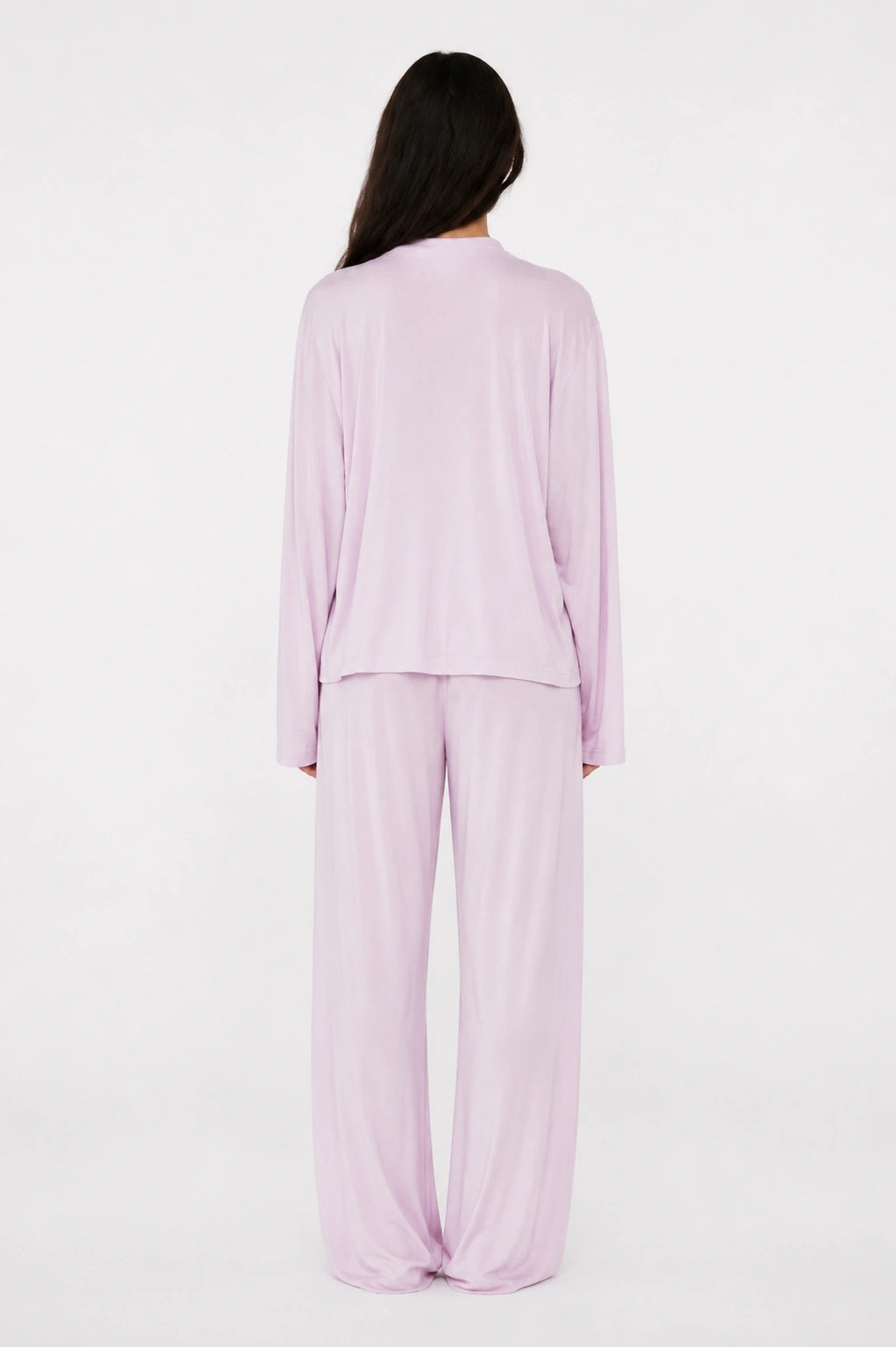 Person wearing a lilac pajama set on a white background