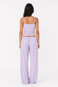 Woman wearing a lavender outfit with a matching top and pants on a white background