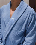 Blue robe with a brand logo on a neutral background