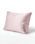 Pink pillow with 'love' embroidery on a white background