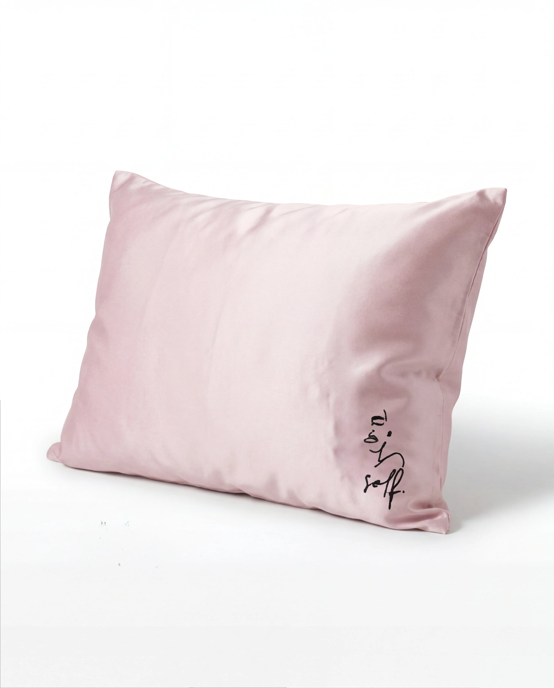 Pink pillow with 'love' embroidery on a white background