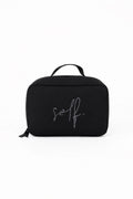 Black toiletry bag with 'self.' branding on a white background