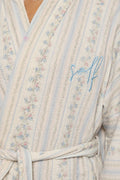 Floral patterned robe with 'Self' embroidery on a wooden background