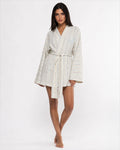 Woman wearing a white floral robe on a white background