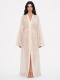 Woman wearing a long, light-colored robe on a white background